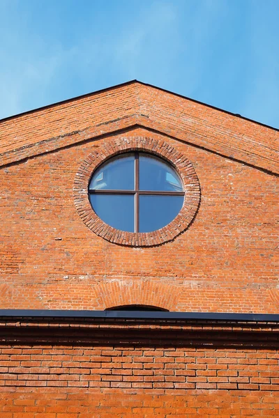 Tegelbyggnaden med ett runt fönster — Stockfoto