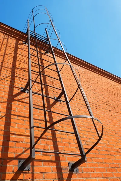 Bakstenen muur met metalen ladder — Stockfoto