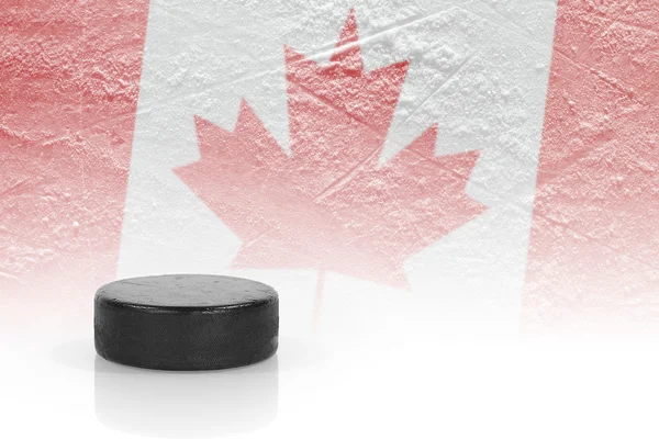 Hockeypuck und eine kanadische Flagge — Stockfoto