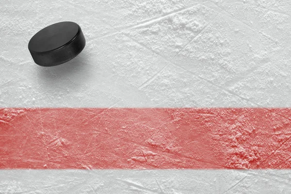 Puck de hockey y una línea roja — Foto de Stock
