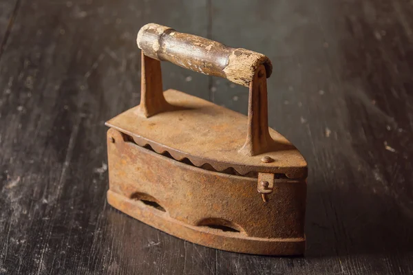 De oude ijzer op een houten tafel — Stockfoto