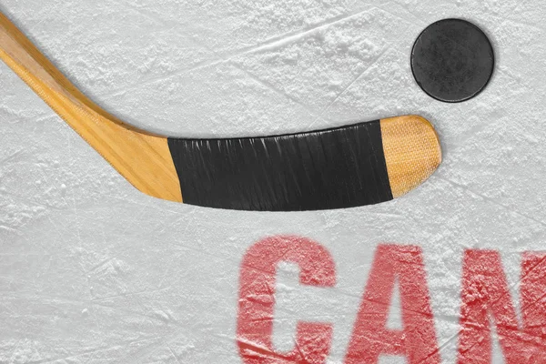 Canadian stick and puck on the ice — Stock Photo, Image