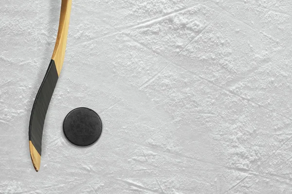 Hockey klubba och puck på isen — Stockfoto