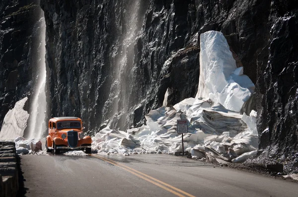 Πορτοκαλί παλαιό αυτοκίνητο οδήγηση μέσω θρυμματισμένο παγετώνα — Φωτογραφία Αρχείου