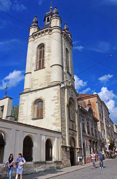 Unbekannte in der Nähe des Glockenturms der armenischen Kathedrale Mariä Himmelfahrt in Lwiw, Ukraine — Stockfoto