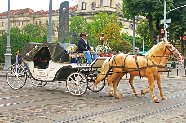 Brougham turístico com pessoas nas ruas no centro histórico da cidade, Lviv, Ucrânia — Fotografia de Stock