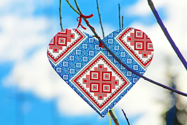 Corazón hecho a mano en el estilo de Vyshyvanka ucraniano en el árbol hecho a mano que los niños hicieron debido al Día de Europa en Vinnytsia, Ucrania. Vyshyvanka es el nombre coloquial para la camisa bordada en traje nacional ucraniano — Foto de Stock