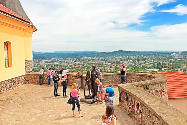 Neznámí lidé v Palanok zámek nebo hrad Mukačevo, Zakarpattja, Ukrajina, postavený ve 14. století. Hrad Palanok jemně zachován a se nachází na bývalém 68 m vysoké sopečné hill — Stock fotografie