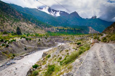 Nepal 'deki Himalaya dağlarında Kali Gandaki nehri ve yolu üzerindeki asma köprü