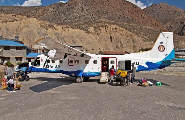JOMSOM, NEPAL - 05 DE OCTUBRE DE 2008: Los pasajeros llegaron y descargaron equipaje del avión de las aerolíneas Sita en el aeropuerto de Jomsom, región de Annapurna, Nepal — Foto de Stock