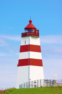 Alnes deniz feneri, Alnes Adası, Norveç. 1852 'de balıkçı teknelerini Alnes' teki küçük balıkçı topluluğunun limanına güvenli bir şekilde götürmek için kuruldu.