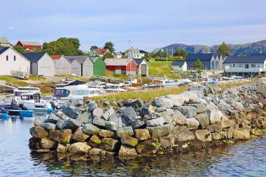 Dalgakıran ve limanı teknelerle dolduran kayaların manzarası, Giske Adası, Norveç