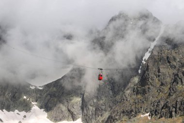 Lomnicky 'e giden kırmızı teleferik kabini High Tatras, Slovakya' nın arka planına dikiliyor