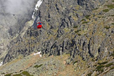 Lomnicky 'e giden kırmızı teleferik kabini High Tatras, Slovakya' nın arka planına dikiliyor