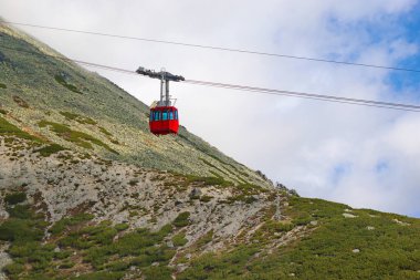 Slovakya, High Tatras 'ın arka planına karşı Lomnicky Stit' e giden kırmızı teleferik kulübesinin yakın görüntüsü