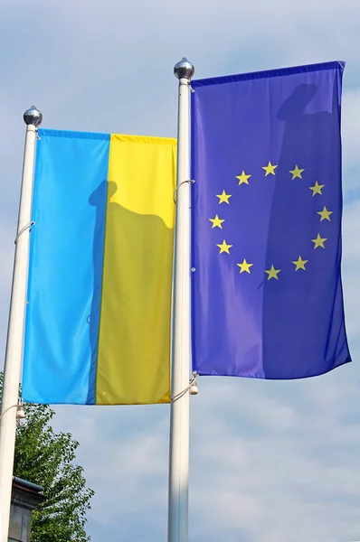 Banderas de la UE y Ucrania en el asta de la bandera — Foto de Stock
