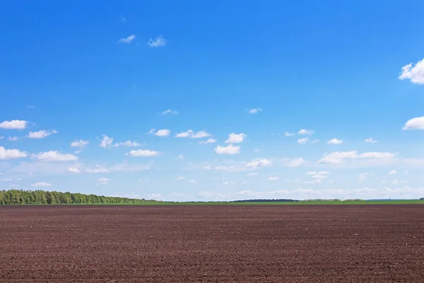 Plowed field in spring and clouds over it — Stock Photo, Image