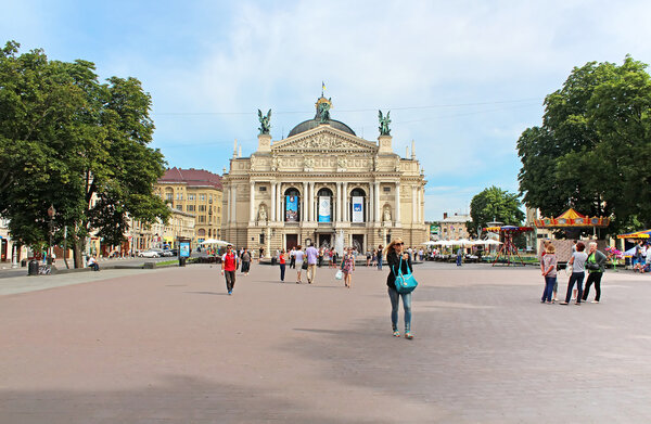 Unidentified tourists near Solomiya Krushelnytska State Academic Opera and Ballet Theatre (1897 - 1900) and the square in front of it, Lviv, Ukraine. Theatre is built in Viennese neo-Renaissance style.