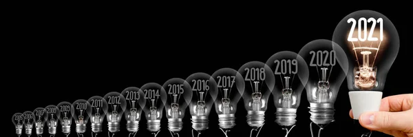 Svítící Žárovka Držena Lidskou Rukou Vláknem Tvaru Nového Roku 2021 — Stock fotografie