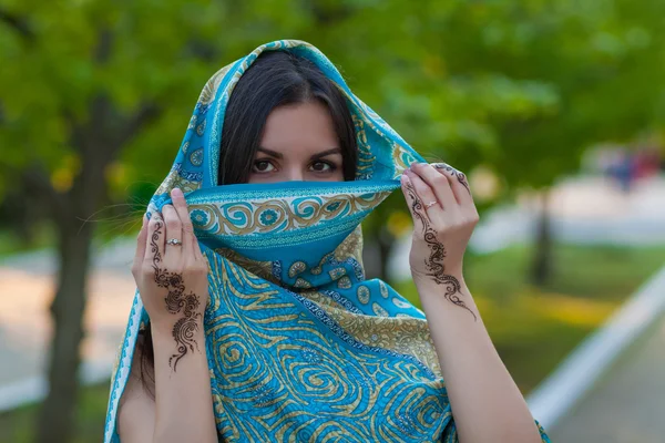 Asian woman hides her face and shows henna tattoo