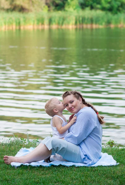 Pregnant woman and her son 2 yo on the green grass. Concept of motherhood — Stock Photo, Image