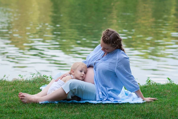Boy and his pregnant mother outdoors, waiting for the baby — Stock Photo, Image