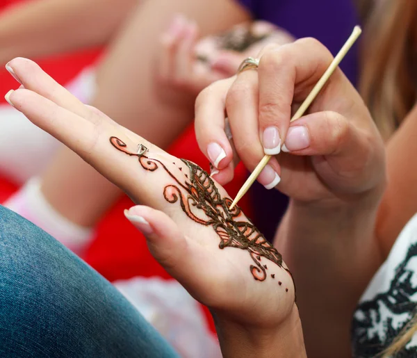 European woman applying henna tattoo — Stock Photo, Image