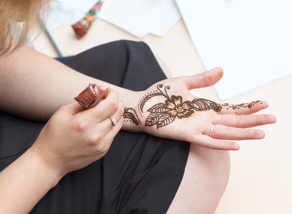 Caucasian woman applying henna tattoo — Stock Photo, Image