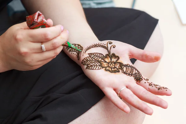 Woman paints henna on her hand — Stock Photo, Image