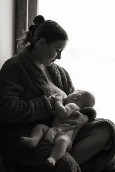 Woman breastfeeding at home, black and white — Stock Photo, Image
