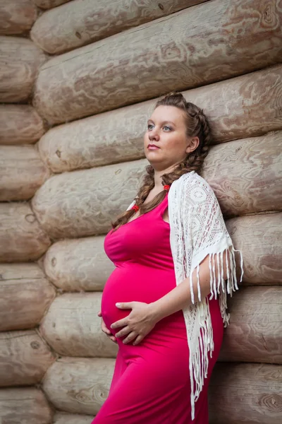 Pregnant woman in red dress outdoors — Stock Photo, Image