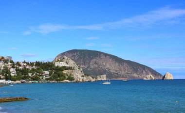 GURZUF, CRIMEA - 1 Ekim 2020 'de Gurzuf, Kırım' da sahil şeridindeki bir dağın arka planına karşı sahil yerleşimi ile körfezin manzarası