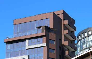 Cam ön panel ve balkonlu ofis binası.