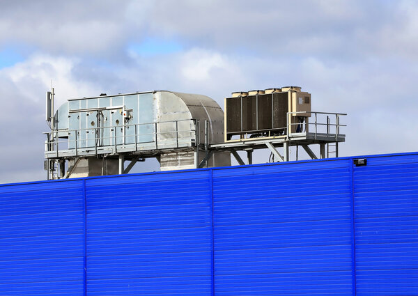 Ventilation pipes and actuators on the roof of an industrial building