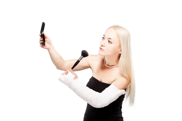 Chica con un brazo roto tratando de poner maquillaje — Foto de Stock