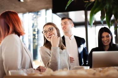 İş adamları, ofis dışında bir kafede yaratıcı toplantılarda eğleniyorlar.