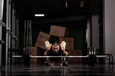 Ağırlıkları olan kaslı bir sporcu. Ağır halterin önünde ısınıyorum.. 