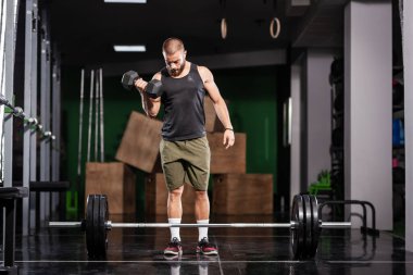 Kaslı sporcu ağırlık kaldırıyor. Ağır halterin önünde duruyorsun.. 