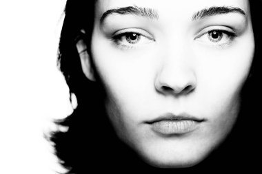 Beyaz arka plana karşı güzel bir genç kadının siyah beyaz stüdyo portresi.