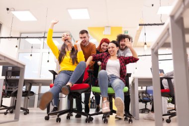 İş arkadaşları iş yerinde eğleniyorlardı. Tekerlekli sandalyedeki erkekleri iten kızlar. Çok ırklı başarılı bir şirket kurma grubu