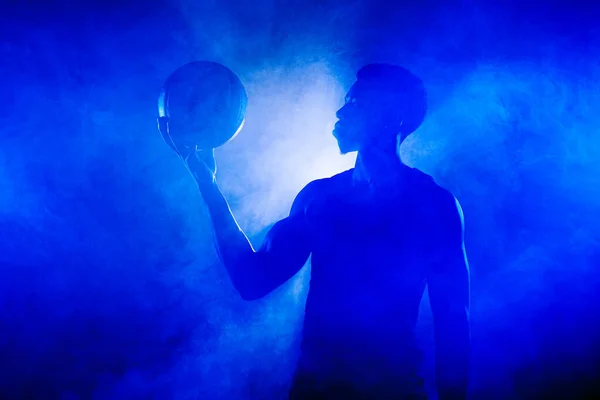 Jugador Baloncesto Sosteniendo Una Pelota Contra Fondo Niebla Azul Silueta — Foto de Stock