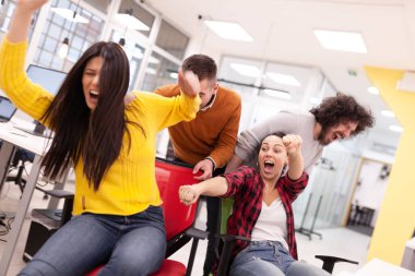 İş arkadaşları iş yerinde eğleniyorlardı. Tekerlekli sandalyedeki erkekleri iten kızlar. Çok ırklı başarılı bir şirket kurma grubu