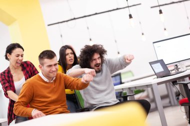 İş arkadaşları iş yerinde eğleniyorlardı. Tekerlekli sandalyedeki erkekleri iten kızlar. Çok ırklı başarılı bir şirket kurma grubu