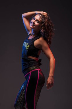 Dans eden bir kızın portresi. Gri arkaplanda mavi ve kırmızı ışıklarla yan aydınlatma