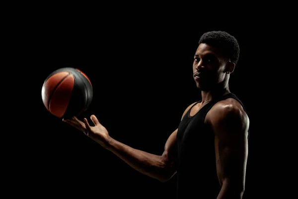 バスケットボール選手は黒を背景にボールを持っている 深刻な集中アフリカ系アメリカ人男性 — ストック写真