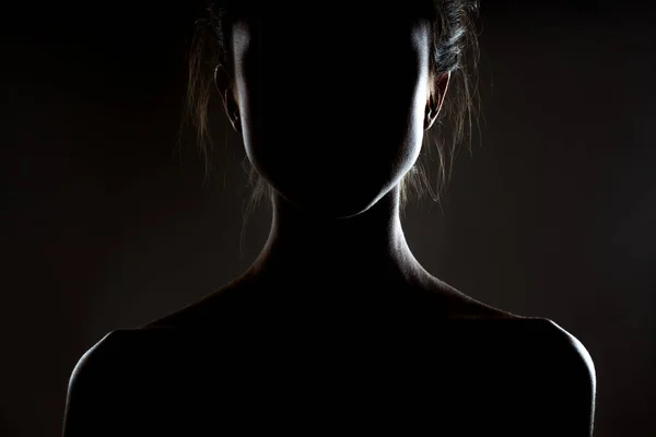 一个漂亮的黑发女孩的轮廓轮廓 深色背景的侧光工作室肖像 — 图库照片