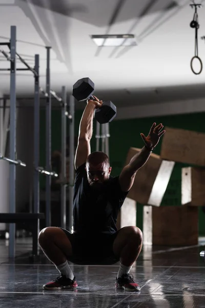 筋肉運動選手のシルエットは非常に重い重みを持ち上げる 屋内で働いてる男 — ストック写真