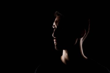 Yandan yakılmış, kısa sakallı, yakışıklı bir erkeğin portresi.