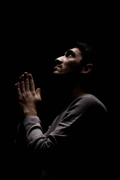 자신감 젊은이가 어두운 방에서 기도하는 위에서 올려다 — 스톡 사진