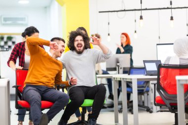 İş arkadaşları iş yerinde eğleniyorlardı. Tekerlekli sandalyedeki erkekleri iten kızlar. Çok ırklı başarılı bir şirket kurma grubu